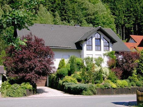 Haus mit dunklem Dach und Hecke im Vordergrund - Kochdumper Steinwiesen
